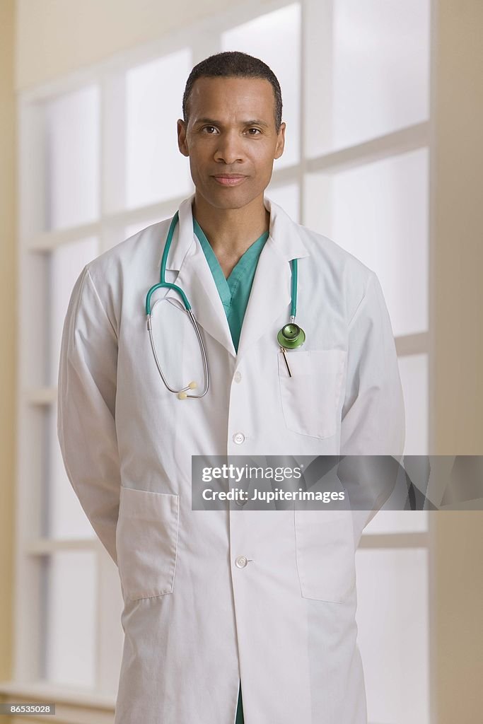 Portrait of doctor with arms behind back