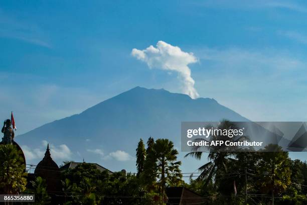 Mount Agung volcano spews steam and smoke into the air as seen from Bangli on Indonesia's resort island of Bali on October 23, 2017. Thousands of...