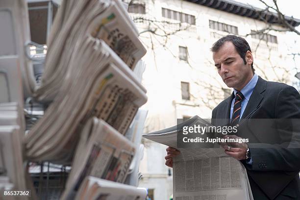 businessman with newspaper at newsstand - news stand stock pictures, royalty-free photos & images