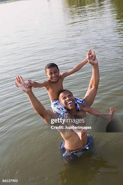 father and son playing in river - boy river looking at camera stock pictures, royalty-free photos & images