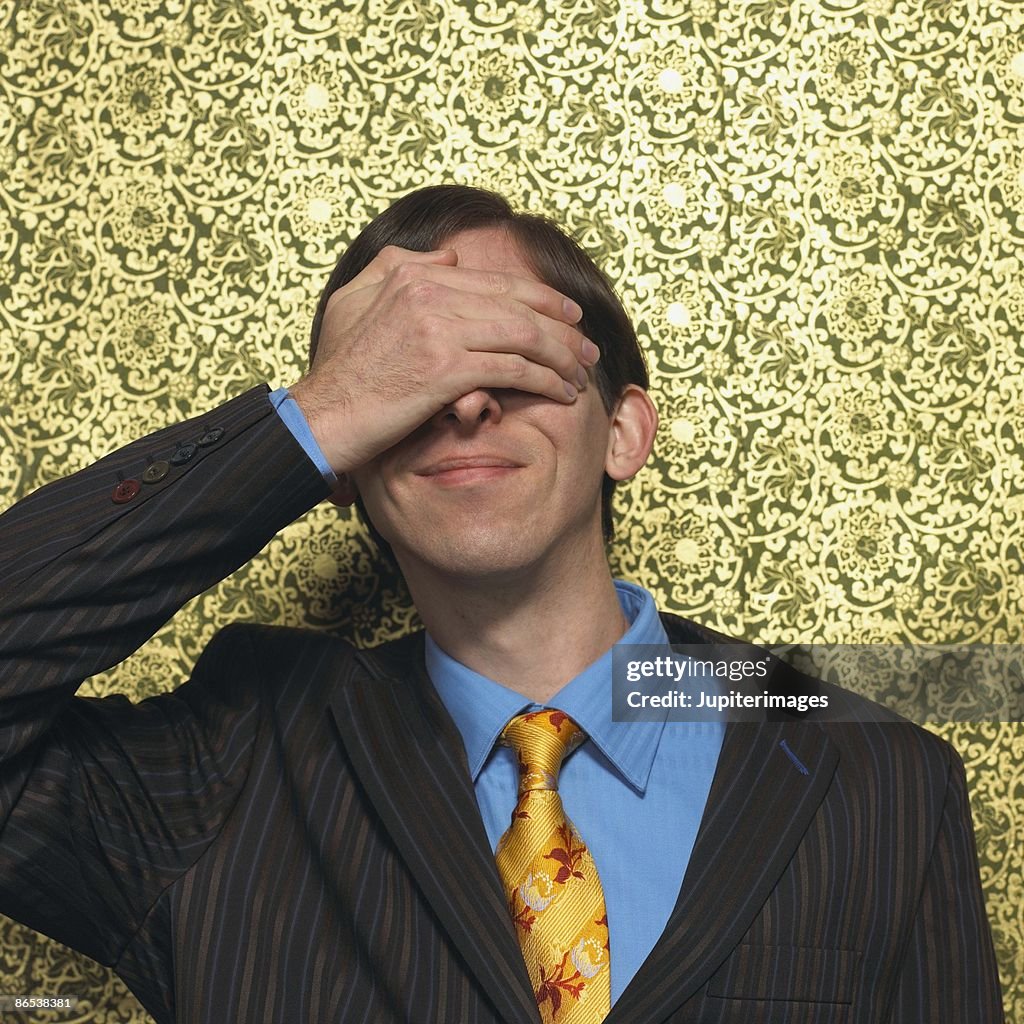 Man covering eyes with hand