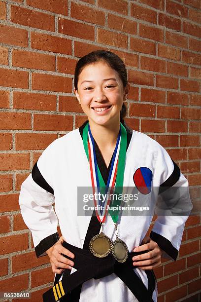 girl in martial arts gi with medals - gi abbigliamento per arti marziali foto e immagini stock