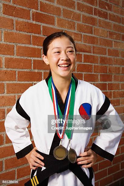 girl in martial arts gi with medals - gi abbigliamento per arti marziali foto e immagini stock