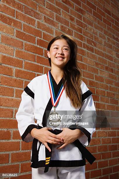 girl in martial arts gi with medals - gi abbigliamento per arti marziali foto e immagini stock