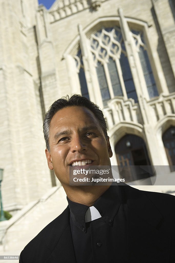 Priest in front of church