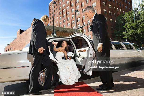 bride and groom getting out of limo - wedding limo stock pictures, royalty-free photos & images