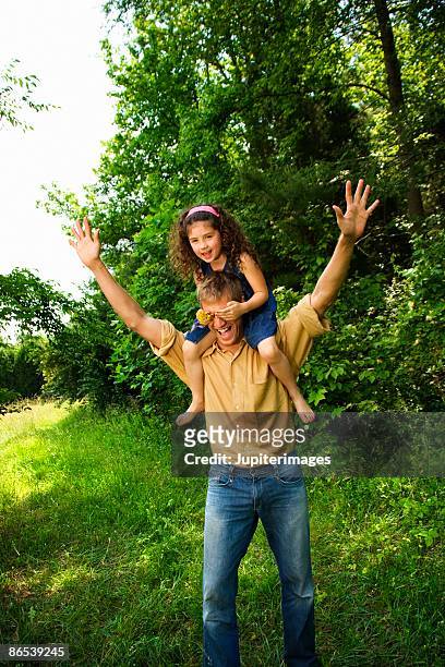man carrying girl on shoulders - brown hair girl stock pictures, royalty-free photos & images