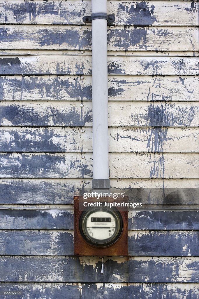 Electric meter on weathered urban wall