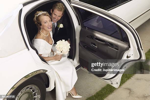 newly married couple stepping out of limousine - wedding limo stock pictures, royalty-free photos & images