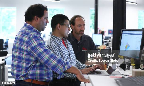 From left, Desktop Metal co-founders CEO Ric Fulop, vice president of software Rick Chin and CTO Jonah Myerberg look at a model being printed in the...