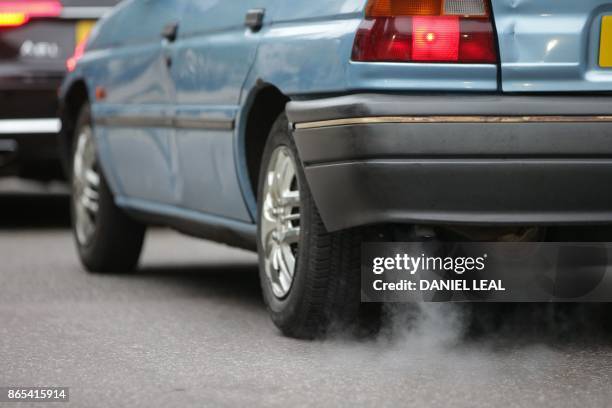 Car emits fumes from its exhaust as it waits in traffic in central London, England on October 23, 2017. - Drivers of the most polluting vehicles will...