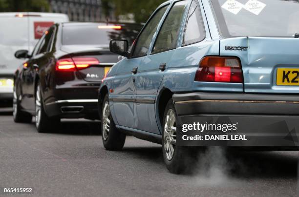 Car emits fumes from its exhaust as it waits in traffic in central London, England on October 23, 2017. - Drivers of the most polluting vehicles will...