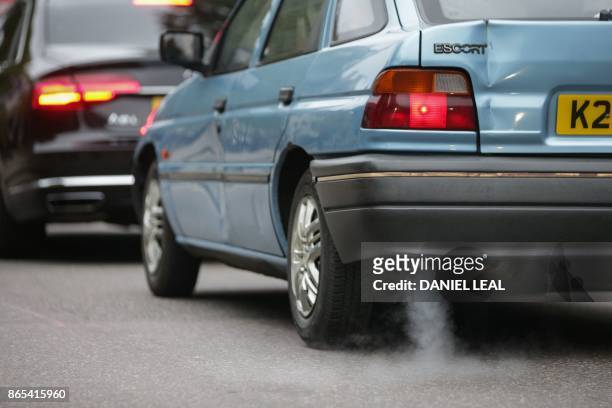 Car emits fumes from its exhaust as it waits in traffic in central London, England on October 23, 2017. - Drivers of the most polluting vehicles will...