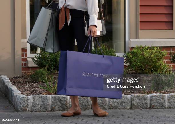 Woman holds a bag from the Stuart Weitzman store at the Woodbury Common Premium Outlets Mall on October 21, 2017 in Central Valley, NY.