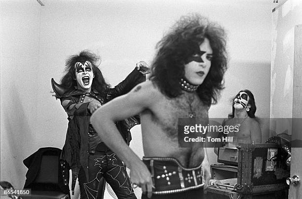 Bassist Gene Simmons of Kiss practices his moves while singer-guitarist Paul Stanley gets ready and drummer Peter Criss relaxes in the dressing room...