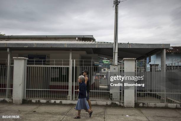 Pedestrians pass in front of Posto de Saude Edna Salles, a public medical center shut down in July, in Duque de Caxias, Rio de Janeiro State, Brazil,...