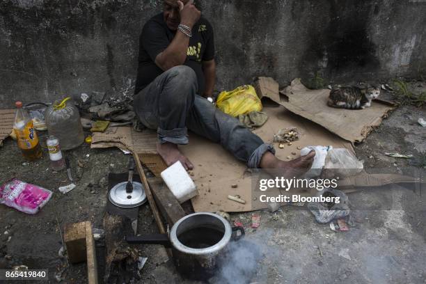 Person cooks beans on the side of a road in cooks beans on the side of a road in Duque de Caxias, Rio de Janeiro State, Brazil, on Thursday, Aug. 24,...