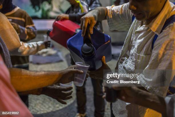 People receive food and coffee from a local charity in Rio de Janeiro, Brazil, on Thursday, Aug. 24, 2017. According to the World Bank, Brazil's...
