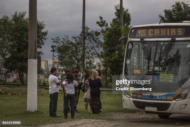 Passengers speak with National Guard members after an assault took place on a public bus in Rio de Janeiro, Brazil, on Thursday, Aug. 24, 2017....