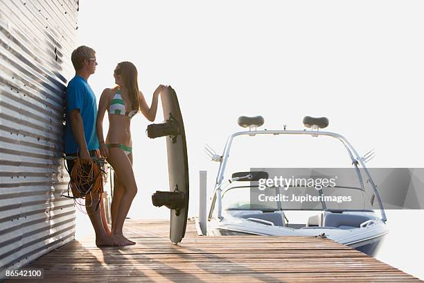 couple with boat and wakeboarder on dock - wakeboarding stock pictures, royalty-free photos & images