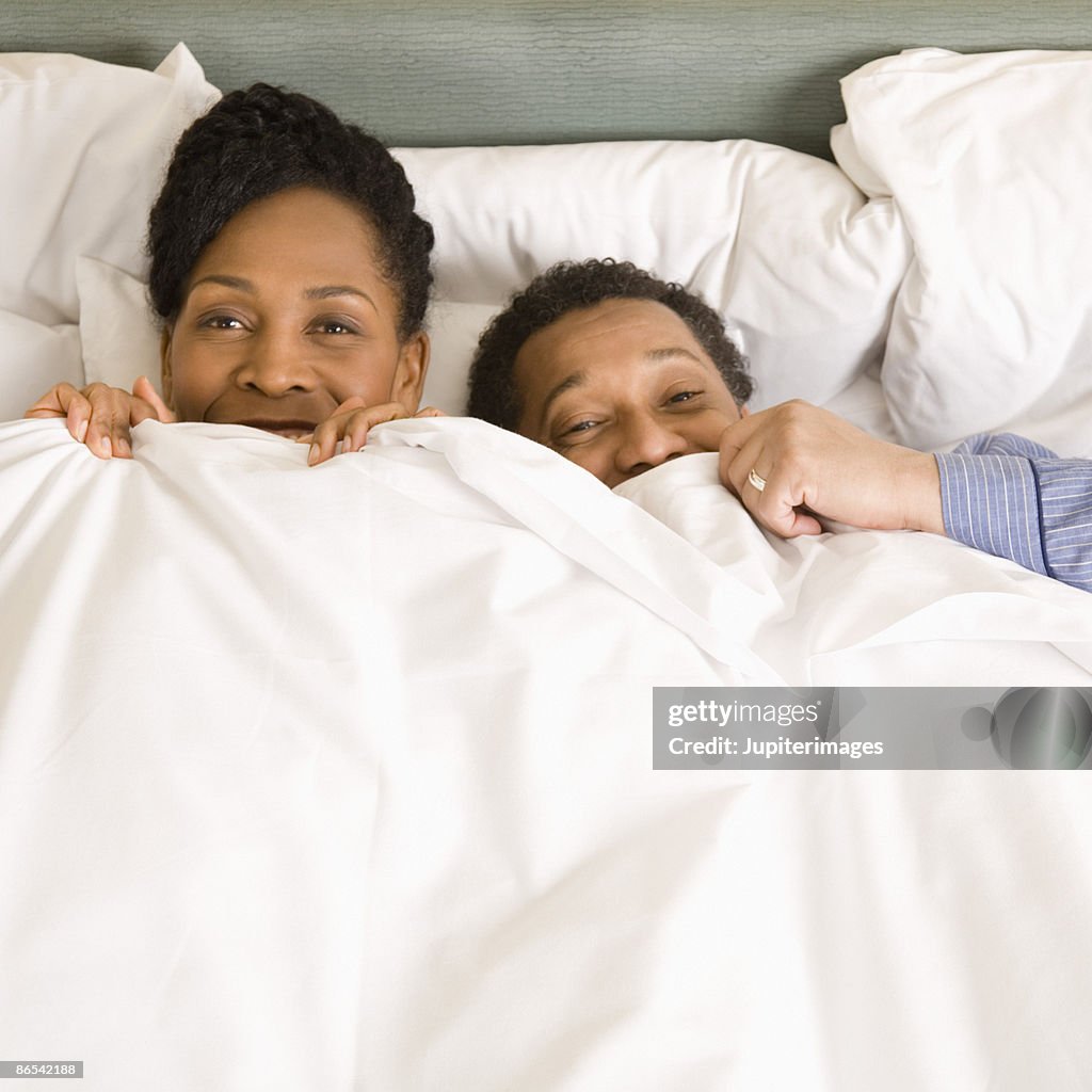 Couple hiding under sheets