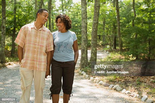 couple holding hands and walking on path - 45 couple stockfoto's en -beelden