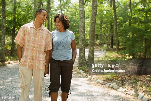 couple holding hands and walking on path - 40 49 years stock pictures, royalty-free photos & images