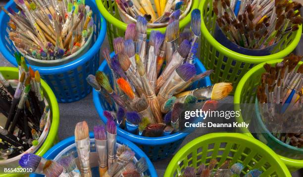 overhead view of dozens of old paintbrushes in containers - pintura em têmpera imagens e fotografias de stock