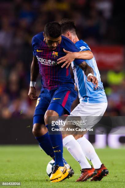 Paulinho of FC Barcelona fights for the ball with Juanpi of Malaga CF during the La Liga match between Barcelona and Malaga at Camp Nou on October...