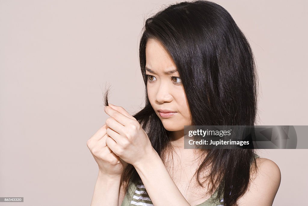Woman inspecting split-ends
