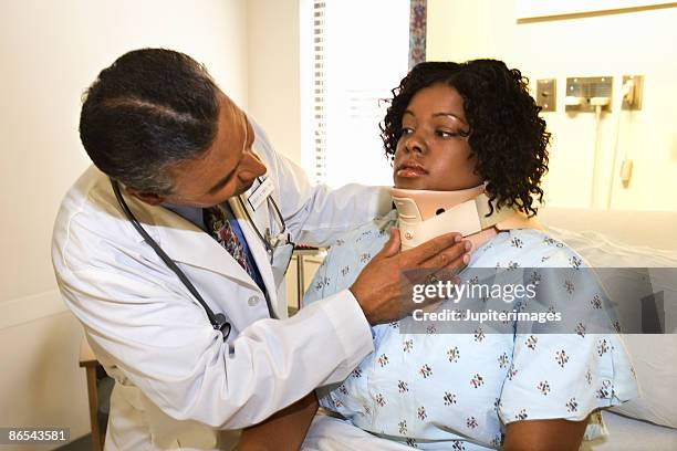 doctor adjusting patient's neck brace - cervical collar stock pictures, royalty-free photos & images