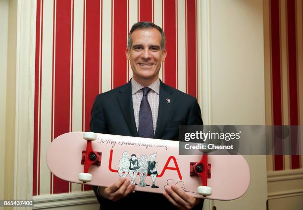 Los Angeles mayor Eric Garcetti shows off a skateboard he will offer to London Mayor Sadiq Khan during a two-day summit of the C40 Cities initiative...