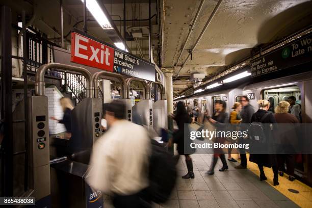 Commuters exit the Wall Street subway station near the New York Stock Exchange in New York, U.S., on Monday, Oct. 23, 2017. U.S. Stocks got off to a...