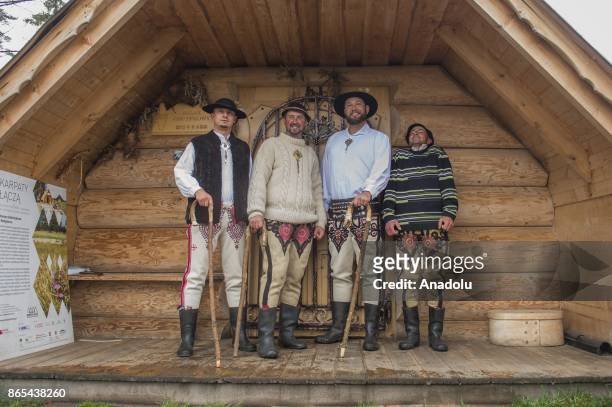 Shepherds pose for a photo after they brought their sheep herds to their barns as the herding season is over as the winter arrives in Czarny Dunajec,...