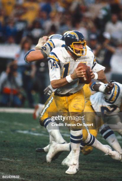 Dan Fouts of the San Diego Chargers drops back to pass against the Oakland Raiders during an NFL football game circa 1980 at Jack Murphy Stadium in...