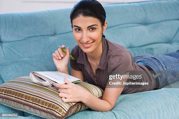 woman working on puzzle - sudoku stock pictures, royalty-free photos & images