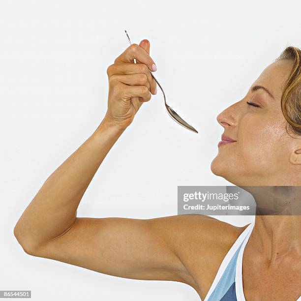 woman eating with smile - femme bras tendu cuillère photos et images de collection