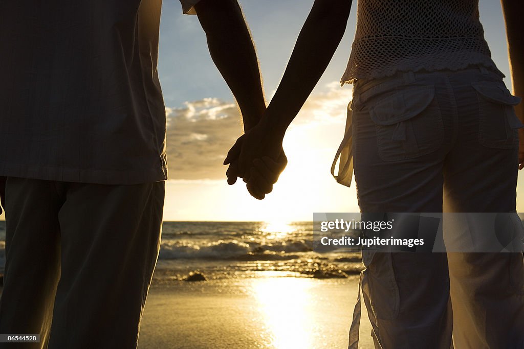 Couple holding hands on beach