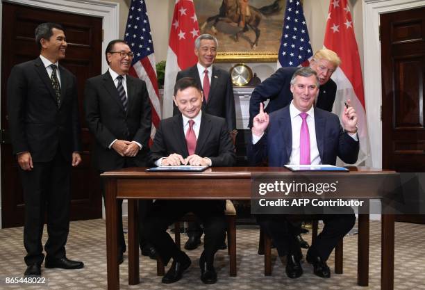 President Donald Trump speaks with Boeing's commercial airplanes CEO Kevin McAllister as Singapore's Prime Minister Lee Hsien Loong stands behing...