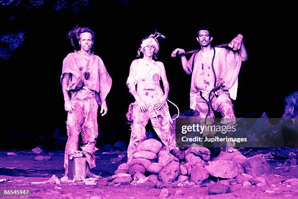 apocalyptic people posing at mouth of cave - cave mouth stock pictures, royalty-free photos & images