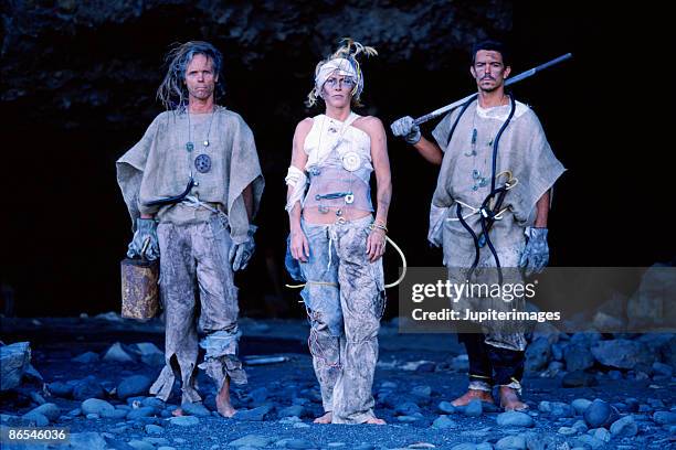 apocalyptic people posing at mouth of cave - cave mouth stock pictures, royalty-free photos & images