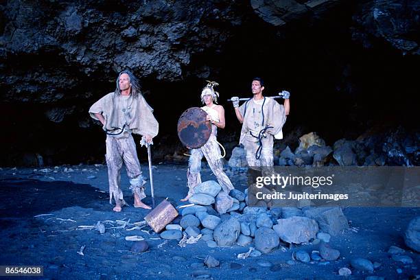 apocalyptic people posing at mouth of cave - cave mouth stock pictures, royalty-free photos & images