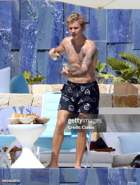 Justin Bieber holds two drinks on October 13, 2017 in Los Cabos, Mexico.