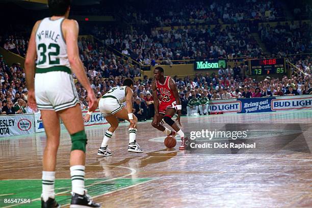 Michael Jordan of the Chicago Bulls moves the ball up court against Dennis Johnson of the Boston Celtics in Game One of the Eastern Conference...