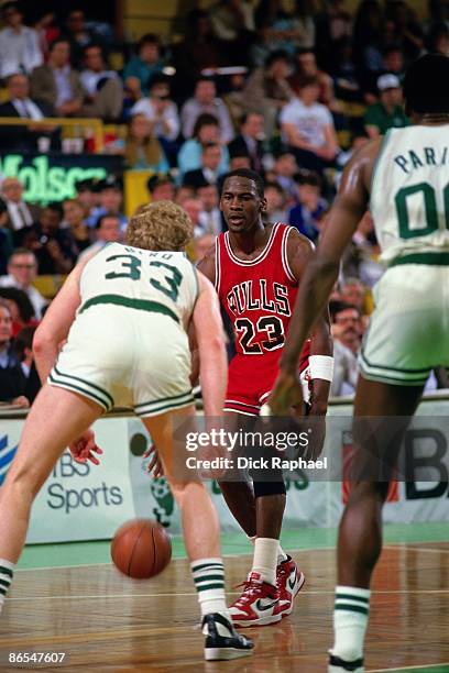 Michael Jordan of the Chicago Bulls moves the ball up court against Larry Bird of the Boston Celtics in Game One of the Eastern Conference...
