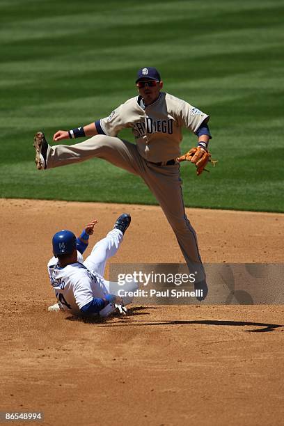 Shortstop Luis Rodriguez of the San Diego Padres leaps over sliding Juan Castro of the Los Angeles Dodgers after forcing the runner at second and...