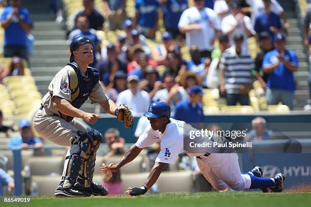 Juan Pierre of the Los Angeles Dodgers slides home for the first run in the bottom of the first inning while catcher Nick Hundley of the San Diego...