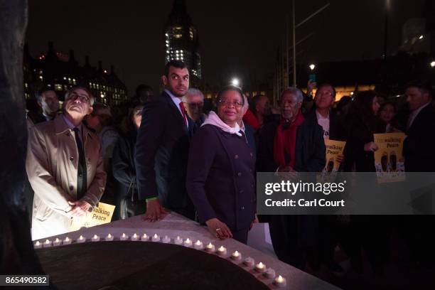 Graca Machel, the window of Nelson Mandela, looks up at his statue taking part in a procession a procession to Parliament Square during the Elders...