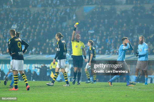 Referee Stefan Johanessen give Erdal Rakip of Malmo FF a yellow card during the allsvenskan match between Malmo FF and AIK at Swedbank Stadion on...