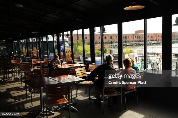 People eat in a cafe in Red Hook, Brooklyn on October 23, 2017 in New York City. Red Hook, like many coastal neighborhoods in New York, was severely...